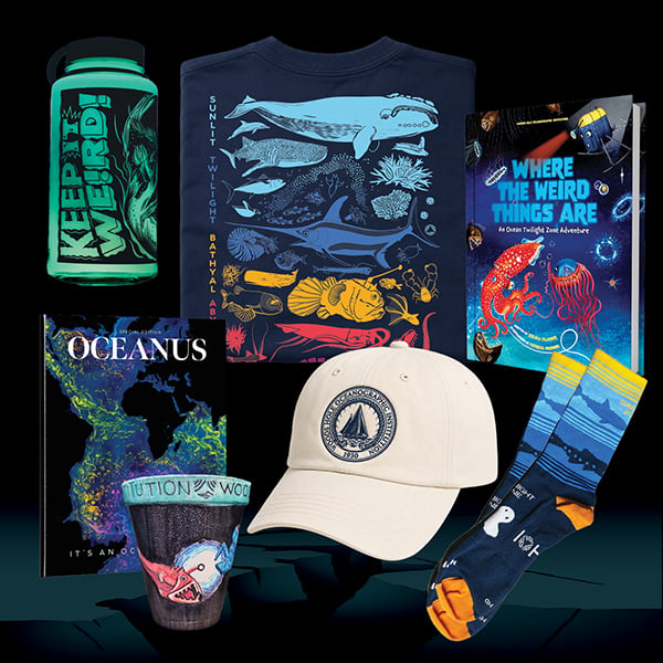 An array of merchandise from the Woods Hole Oceanographic Institution featuring a "Keep It Weird" glow-in-the-dark water bottle, a logo hat, a copy of Oceanus Magazine, a T-shirt showing the ocean zones, a pair of twilight zone-inspired socks, a cup from HOV Alvin, and a copy of the children's book, "Where the weird things are."